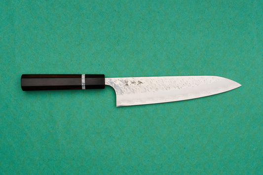 Yoshimi Kato SG2 Hyo Gyuto 210mm features a hand-hammered blade with kanji engraving and a dark octagonal handle, ideal for versatile culinary tasks, reflecting Japanese craftsmanship excellence.