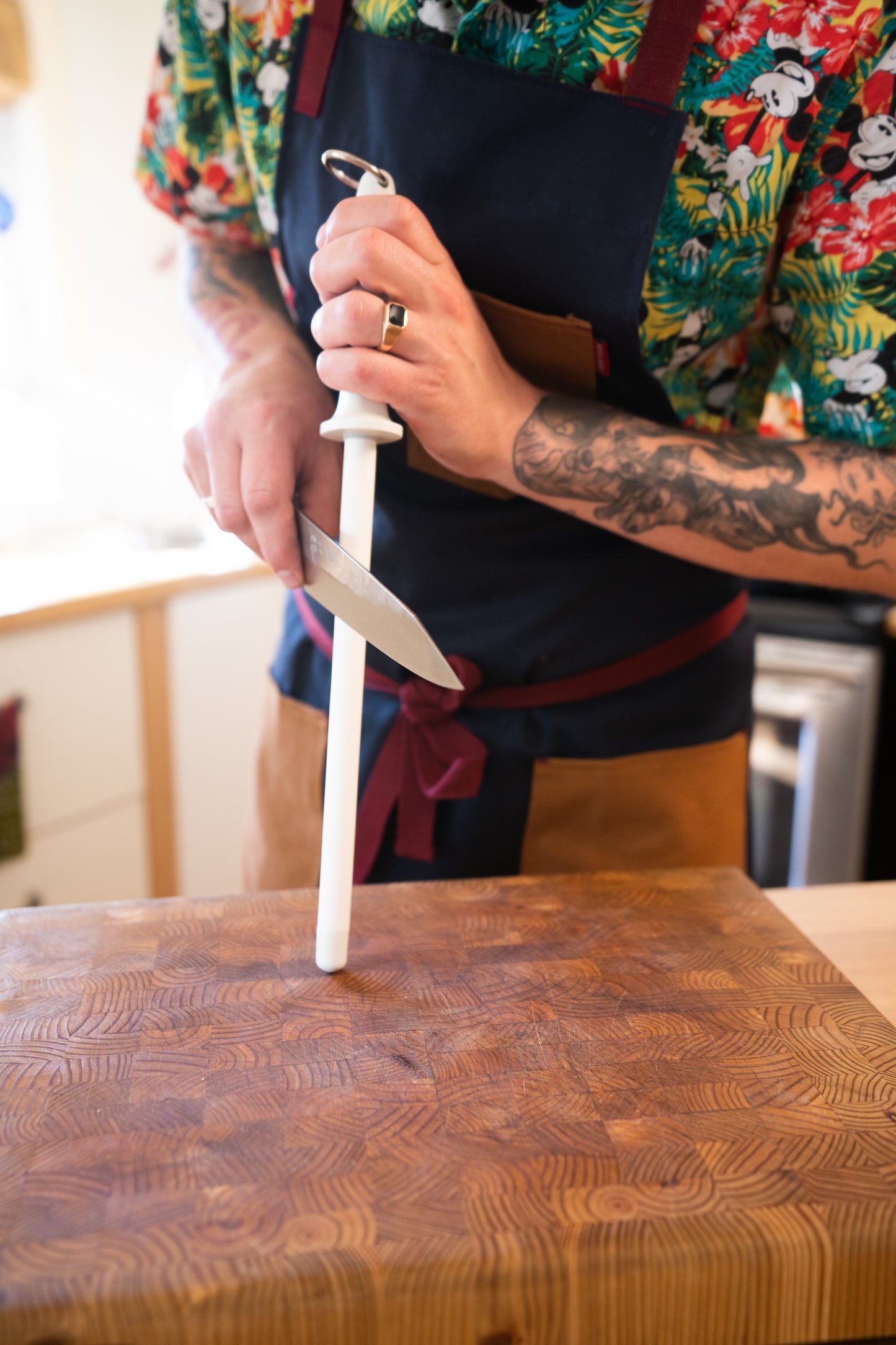 Chef sharpening a knife on a honing rod during the Kitchen Knife 101 — InglewooDIY workshop, focusing on Japanese knife skills and safety.